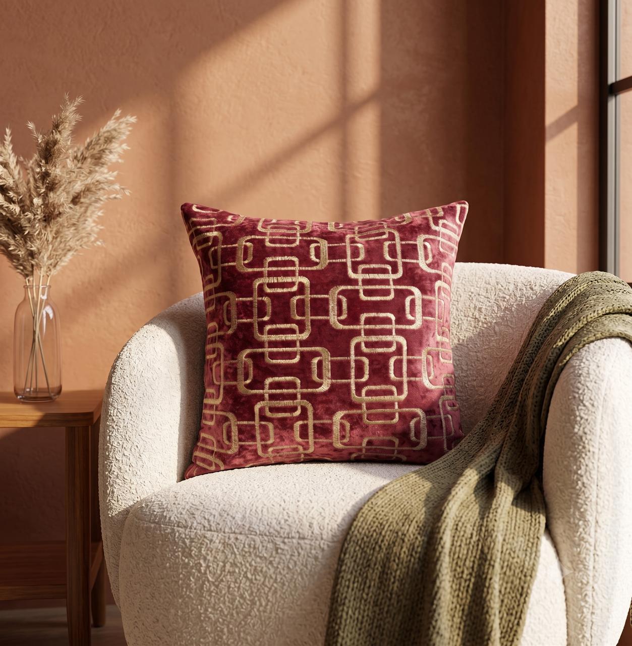 Golden chain embroidered cushion cover on rich burgundy velvet base