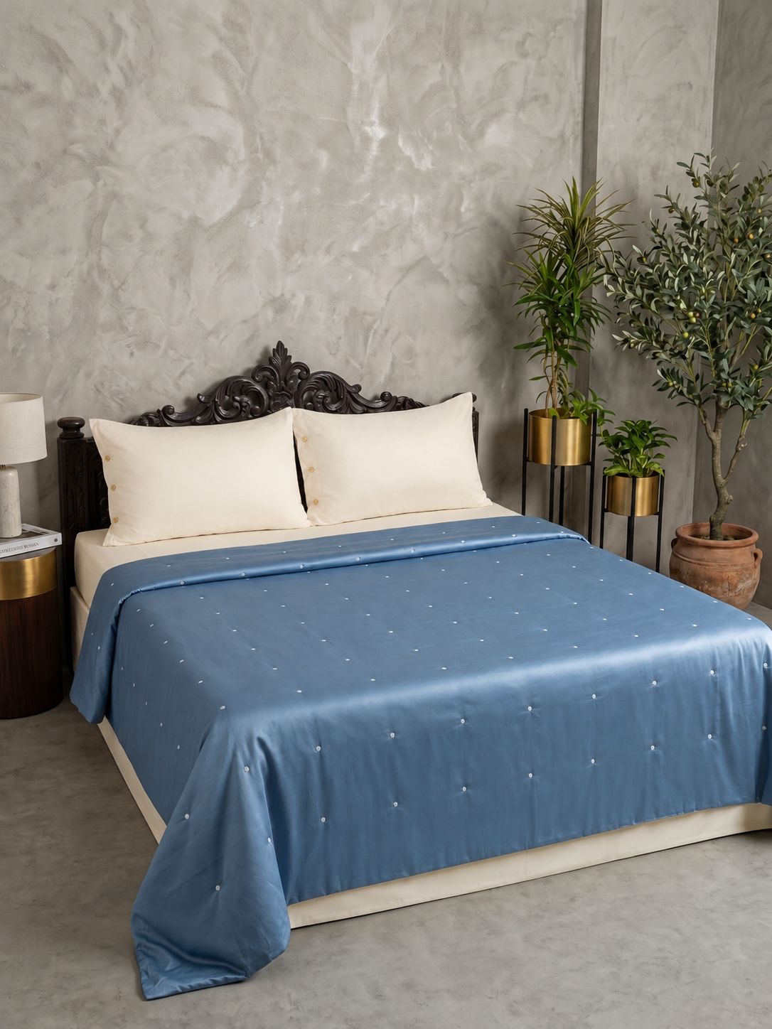 Steel blue all season comforter with white dot tufting on bed with cream pillows